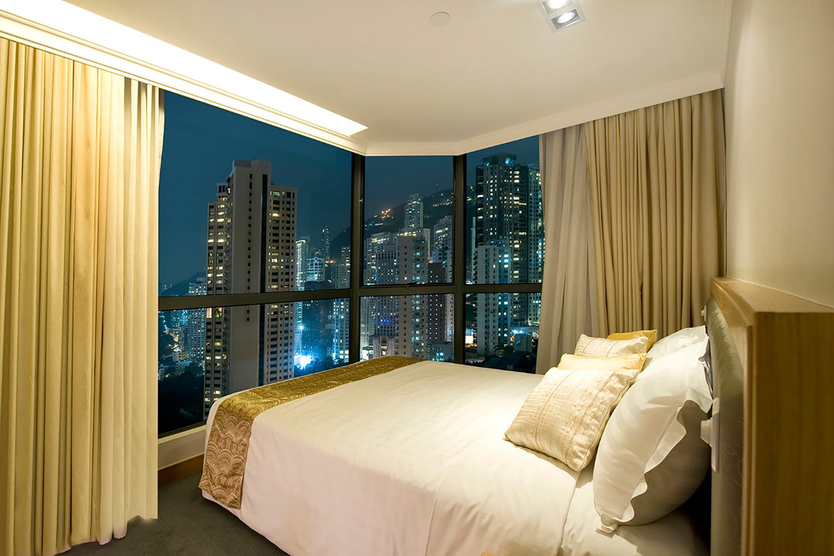 Hotel room at night with view of Hong Kong island skyline